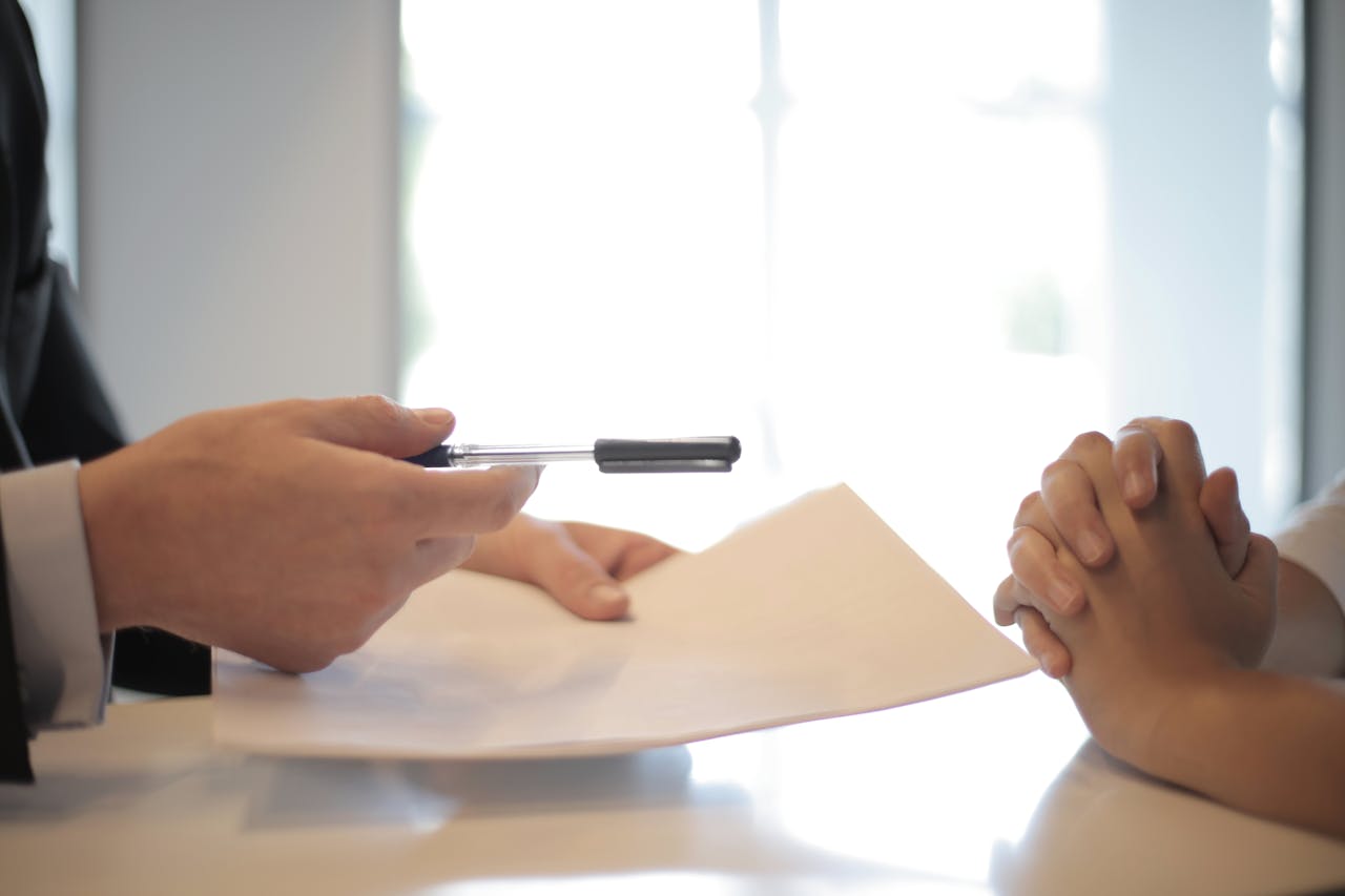 home-hero Close-up of a contract signing with hands over documents. Professional business interaction.